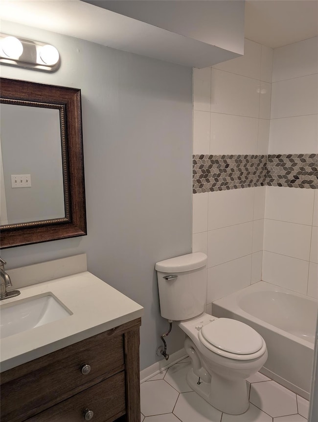 Bathroom featuring baseboards, toilet, and vanity