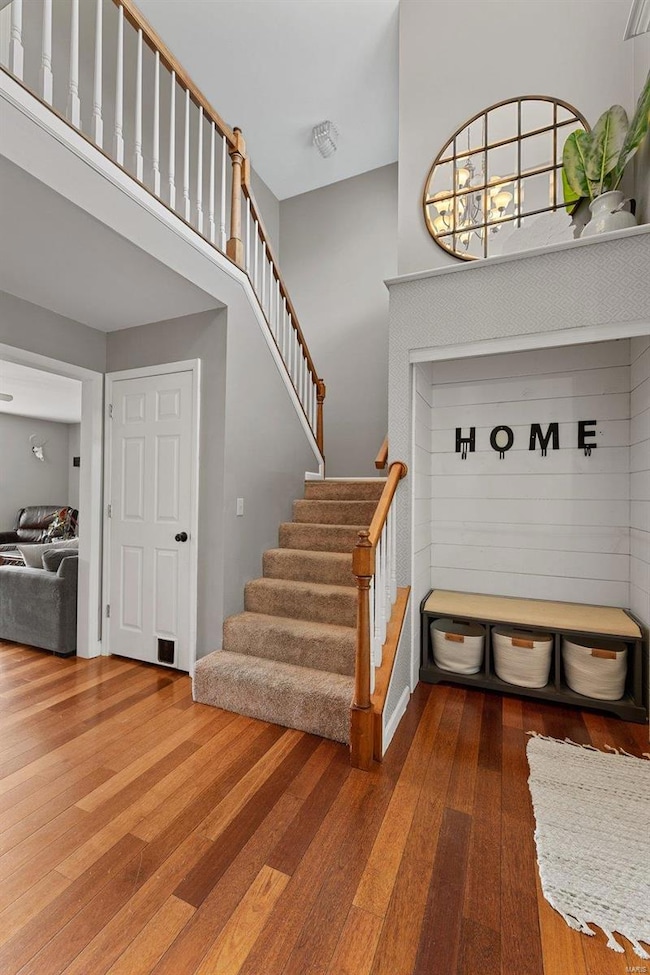 2 story entry foyer has bench with storage, hardwood flooring and opens to living, dining, kitchen and breakfast rooms.