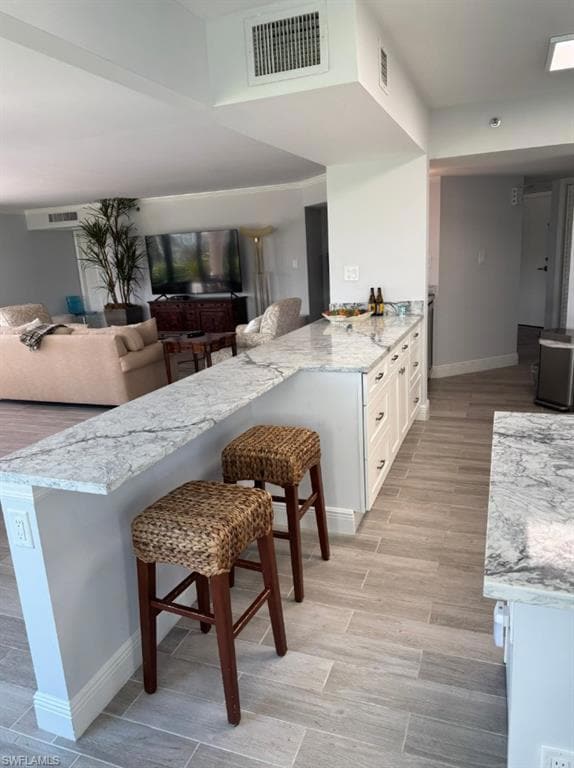 Kitchen with visible vents, white cabinets, a kitc