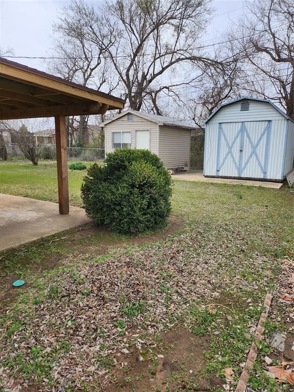 View of yard featuring a garage, an outbuilding, a