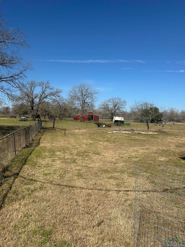 View of yard featuring a rural view, fence, and an
