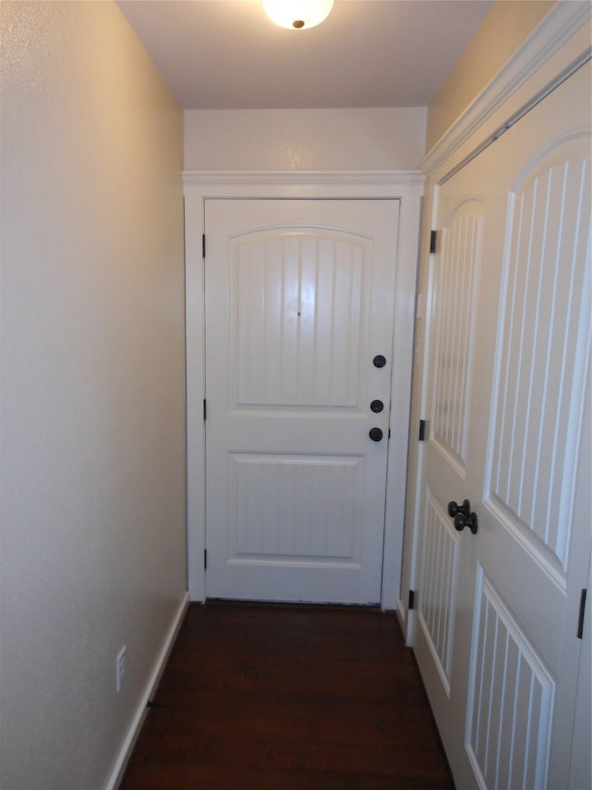 Doorway to outside featuring wood finished floors and baseboards