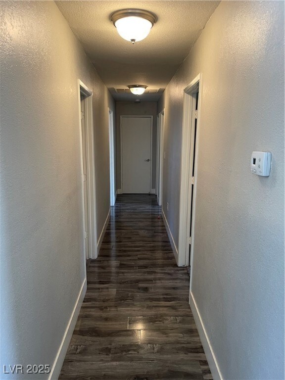Corridor with a textured ceiling, dark wood-style