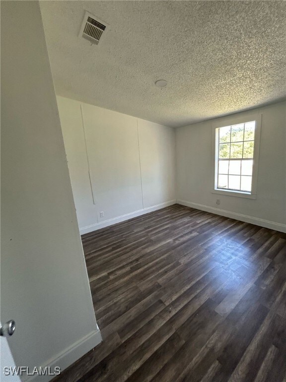 Empty room featuring a textured ceiling, baseboard