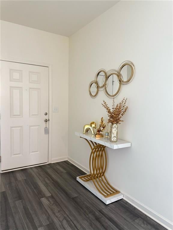 Foyer entrance with dark wood-style floors and baseboards