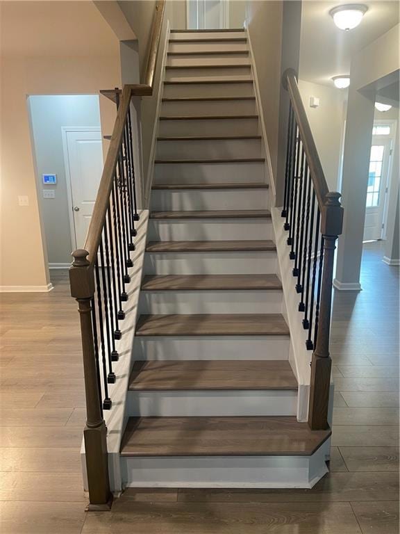 Stairs featuring baseboards and wood finished floors