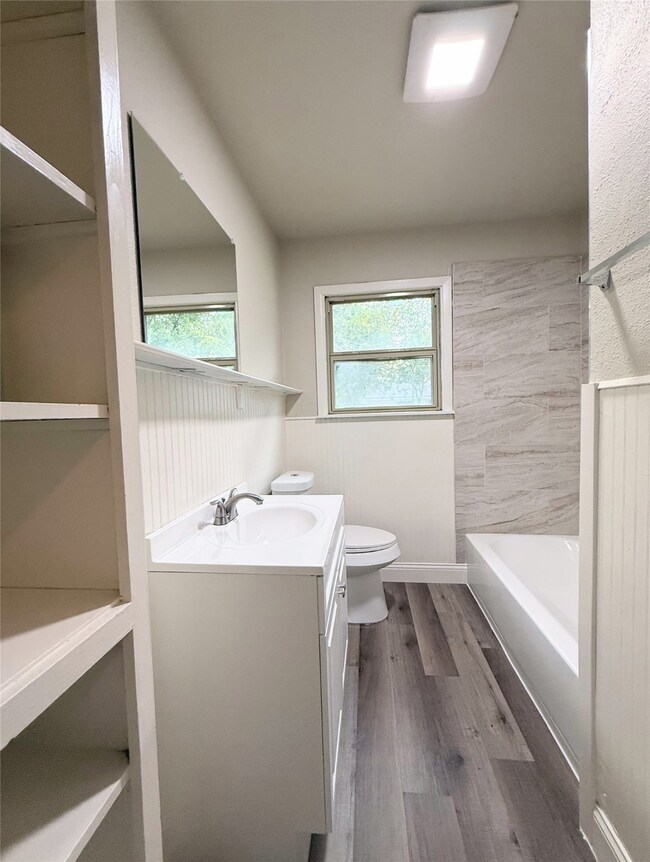 Full bathroom featuring dark wood finished floors, vanity, and shower / bath combination