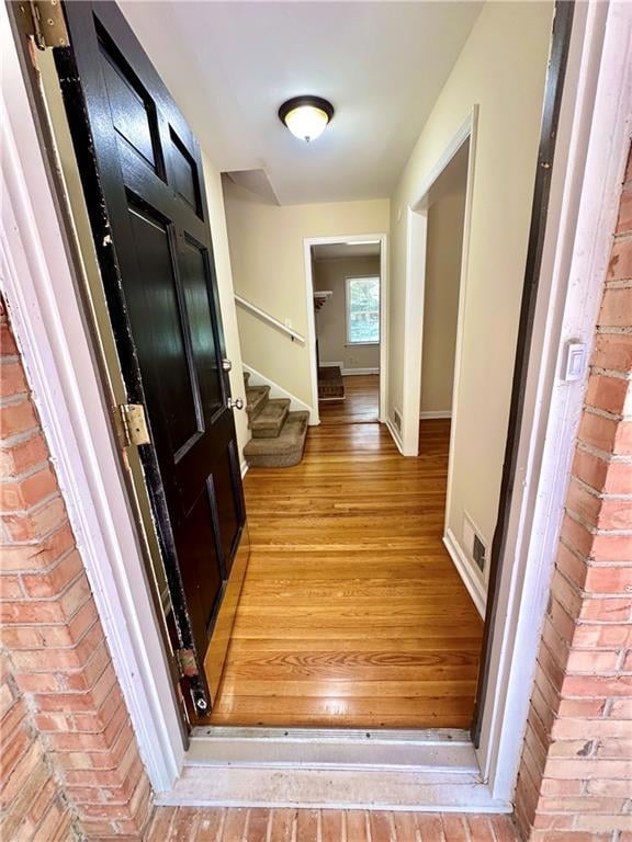 Corridor featuring stairway and light wood-style flooring