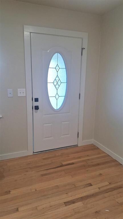 Front door featuring light wood flooring