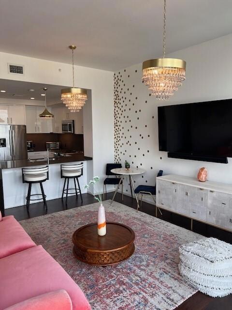 Living area featuring a chandelier, visible vents