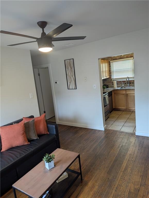 Living area featuring a ceiling fan, visible vents