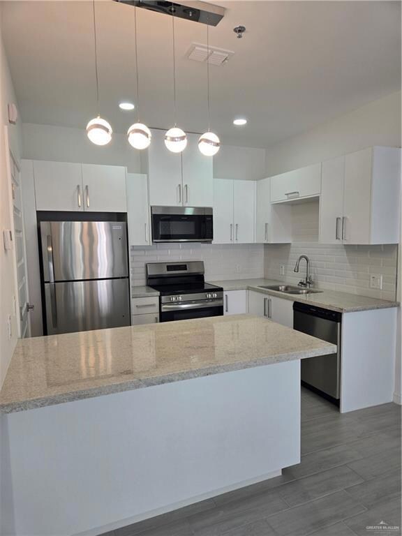 Kitchen with electric range, fridge, dishwasher, a sink, and a peninsula