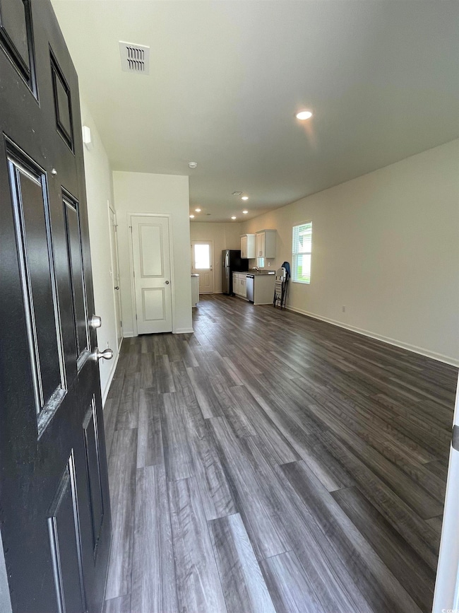 Unfurnished living room with dark wood finished floors and recessed lighting