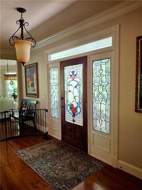 Foyer featuring stained glass front entry-way, woo