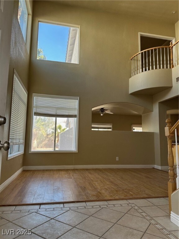 Unfurnished living room featuring a high ceiling,