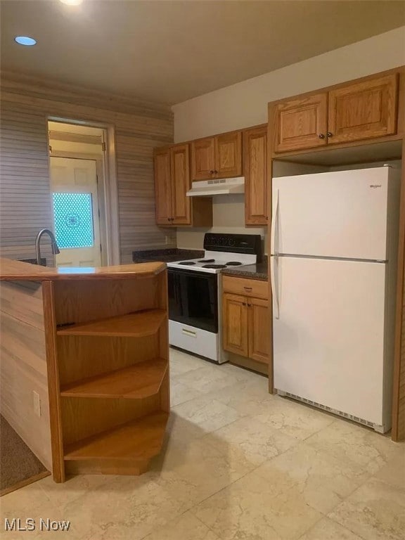 Kitchen with white appliances, under cabinet range hood, open shelves, and brown cabinets