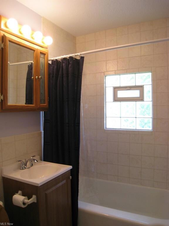 The main floor full bath features a ceramic tiled 