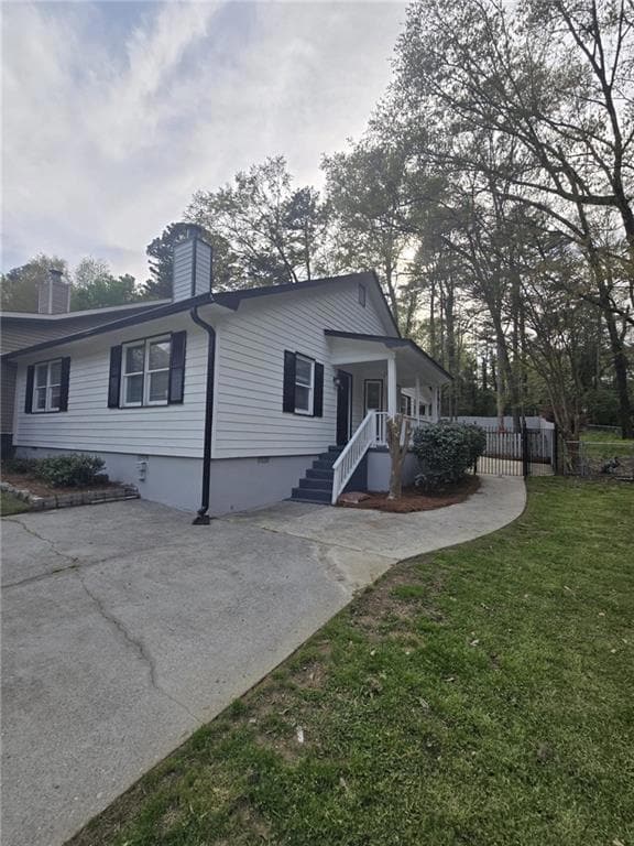 View of side of property with a lawn, driveway, cr