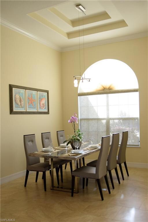 Dining area featuring a raised ceiling and crown m