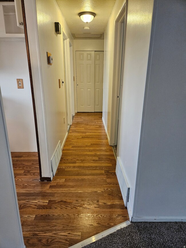 Hallway featuring dark wood finished floors and baseboards
