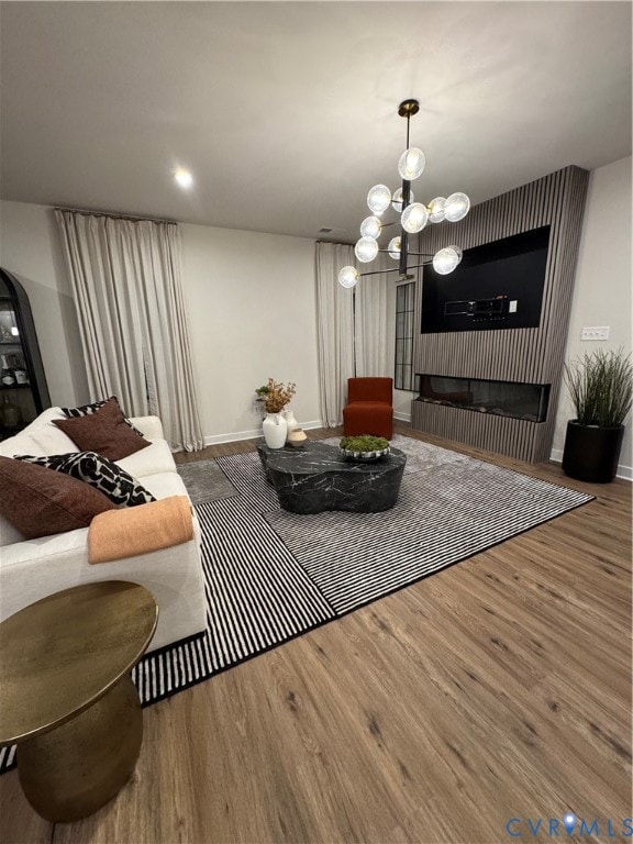 Living room with wood finished floors, a chandelier, and recessed lighting