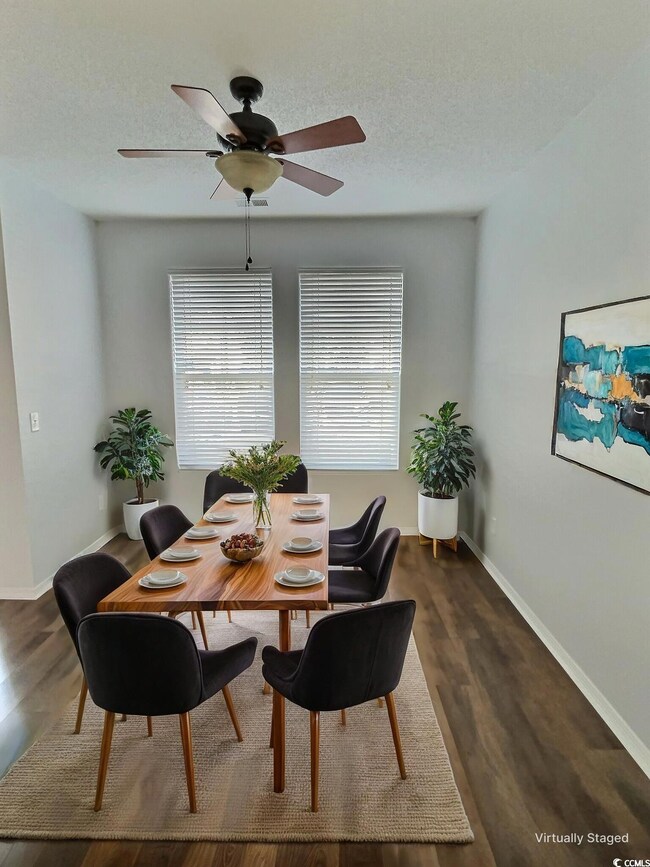 Dining room with baseboards, a ceiling fan, dark w