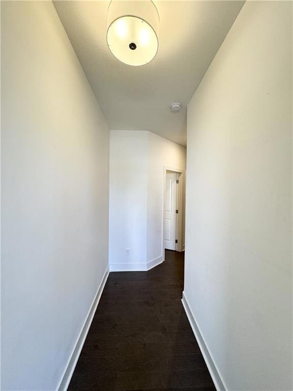 Hallway with baseboards and dark wood-style floors