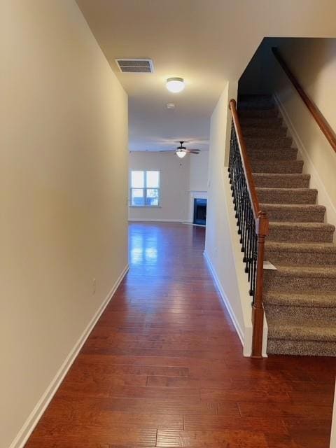 Hallway with wood finished floors and stairs