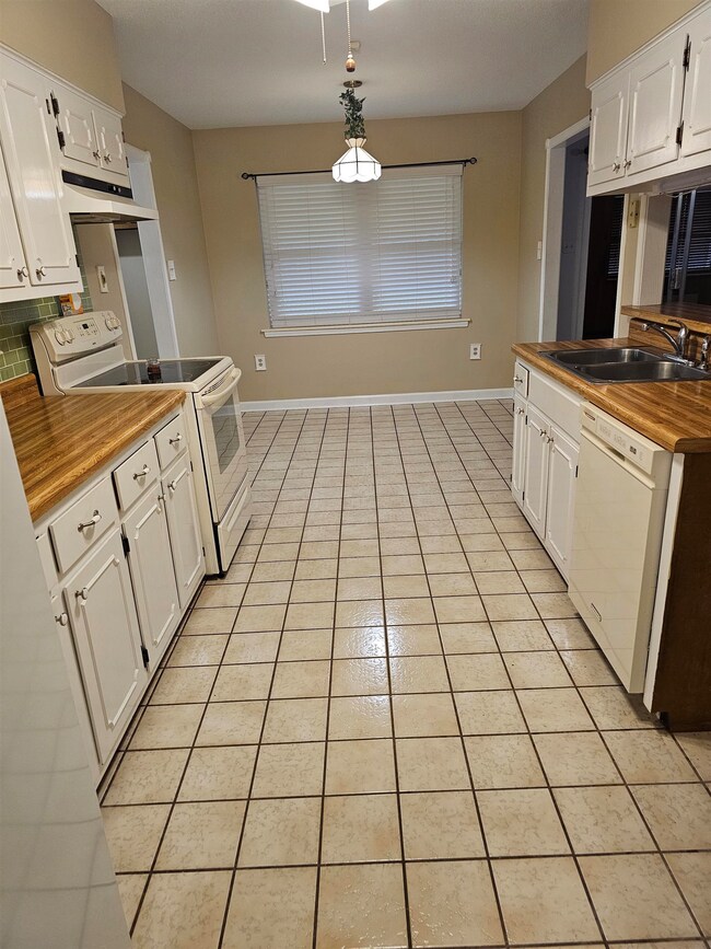 Kitchen featuring butcher block countertops, white