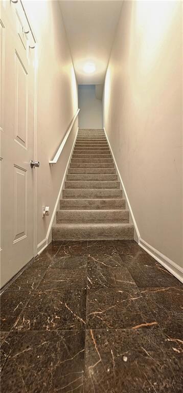 Stairs with baseboards and marble finish flooring