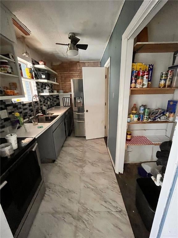 Kitchen with range with electric cooktop, open shelves, stainless steel fridge, a sink, and ceiling fan