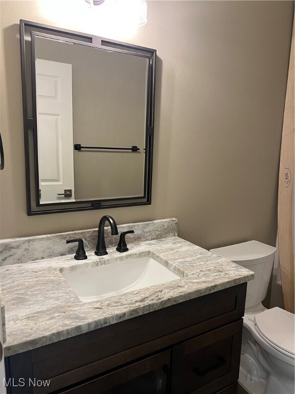 Half bathroom featuring toilet and vanity