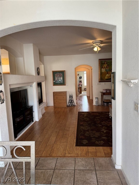 Unfurnished living room with arched walkways, a gl