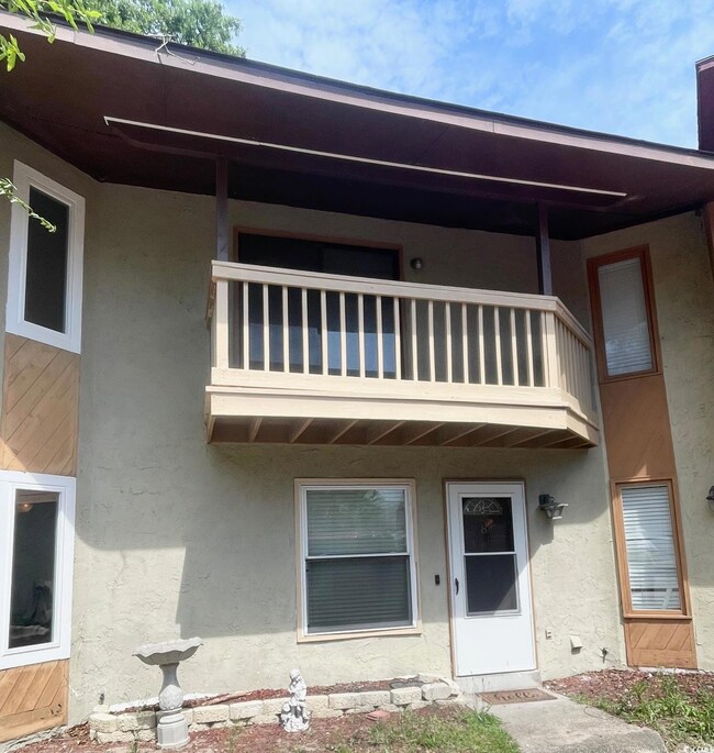 Back of house with a balcony and stucco siding