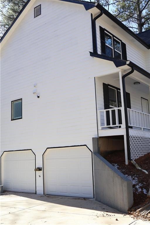 View of side of home featuring a garage and covere
