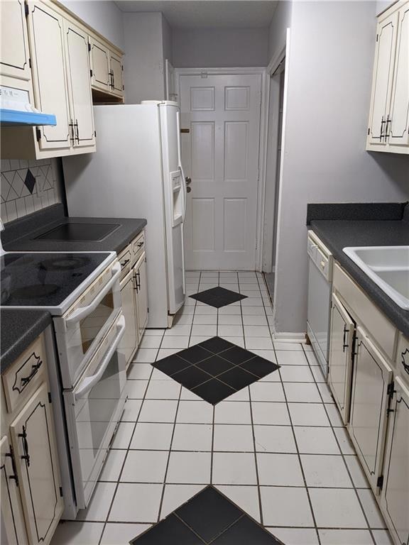 Kitchen with backsplash, custom exhaust hood, white appliances, and light tile floors