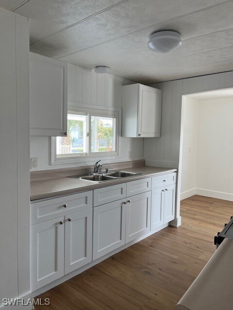 Kitchen with white cabinets, light wood-type floor