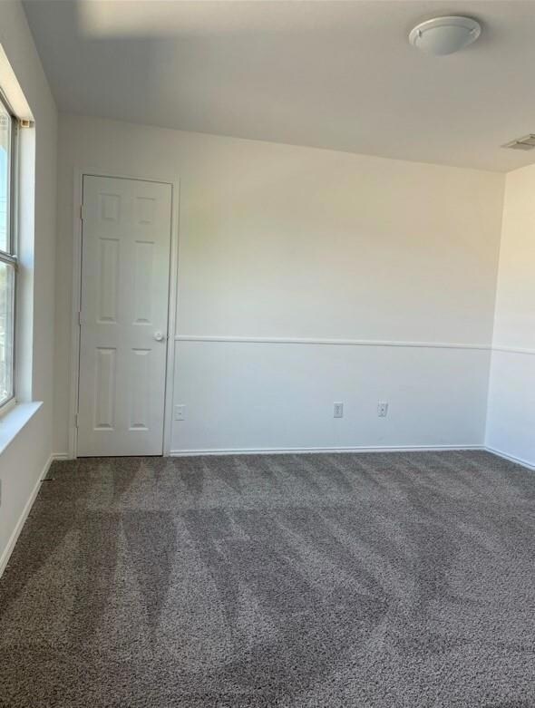 Unfurnished room featuring dark carpet