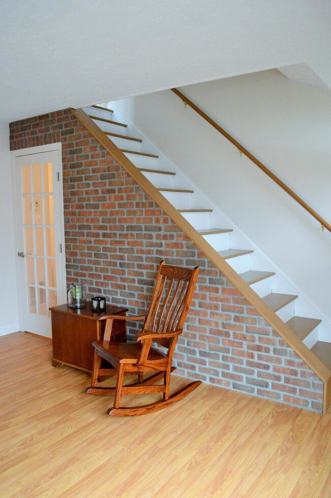 Open stair case with brick accent wall