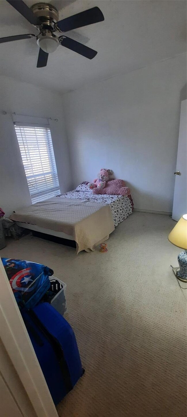 Carpeted bedroom featuring ceiling fan