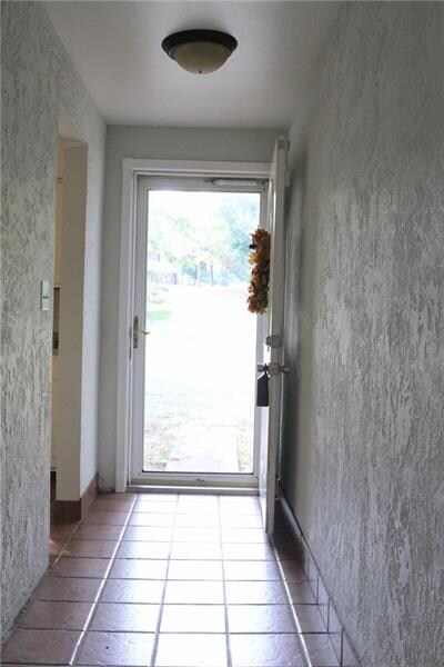 Front entry hall tile flows into the kitchen.