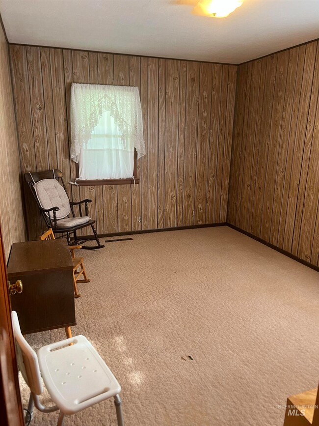 Living area with wooden walls and carpet