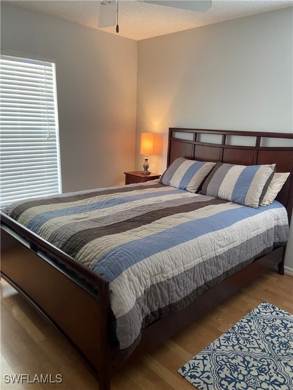 Bedroom featuring a textured ceiling and wood fini