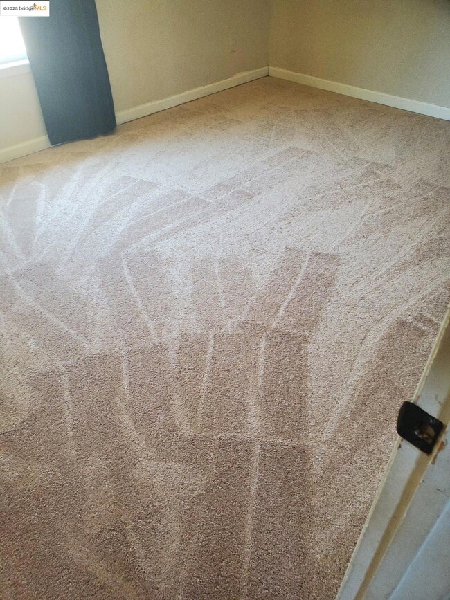 Detailed view of carpet flooring and baseboards