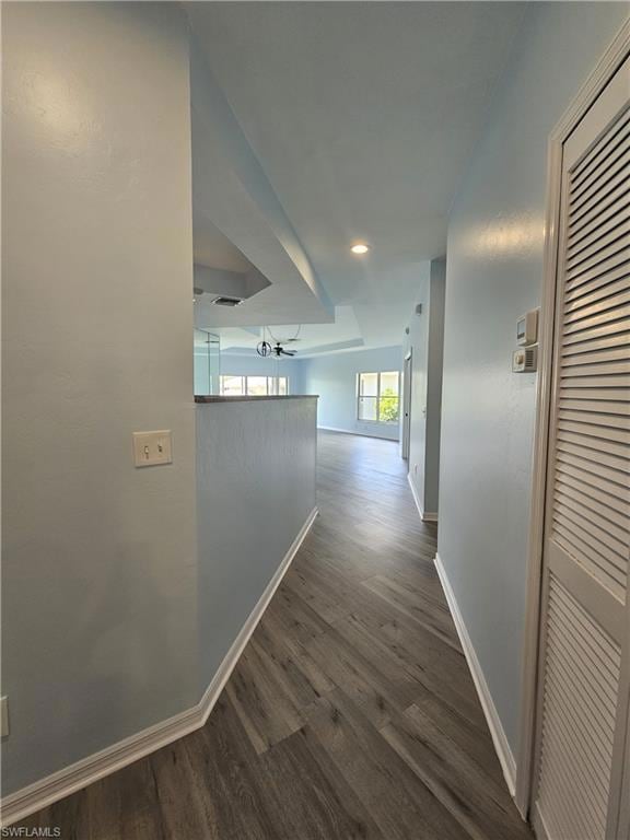 Hallway featuring baseboards, dark wood finished f