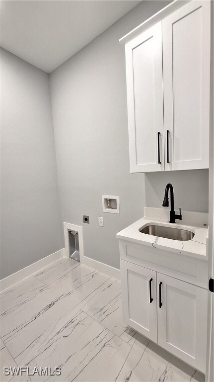 Washroom with washer hookup, cabinets, sink, and e