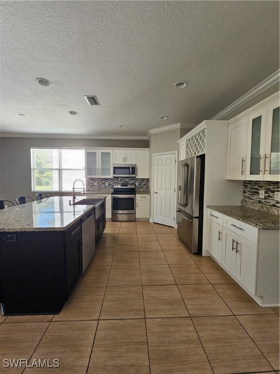 Kitchen featuring sink, white cabinetry, range, re