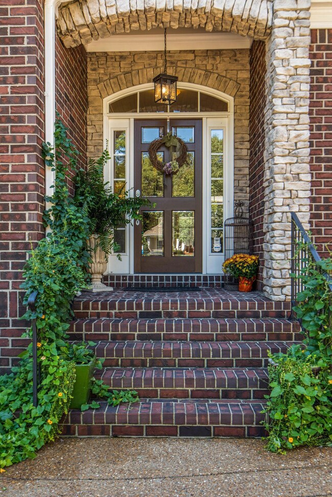 Welcome guests into the home via covered porch with stone detail