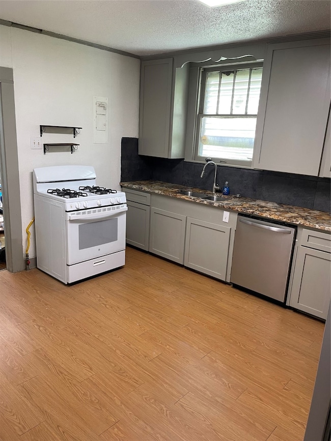 This kitchen features modern gray cabinets, a gas