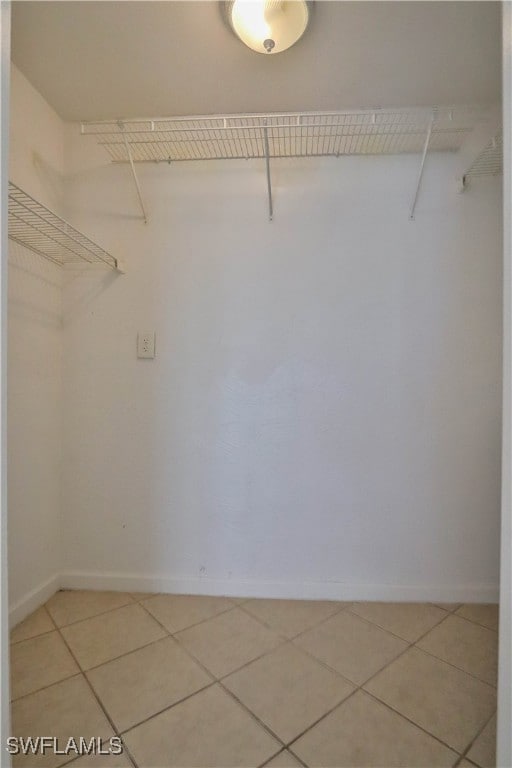 Walk in closet with light tile patterned floors